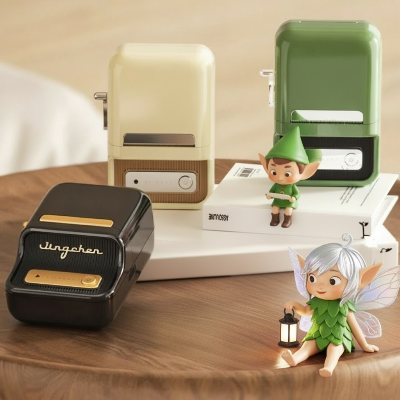 imprimante thermique vert beige et noir posées sur la table, 2 petits lutins assis